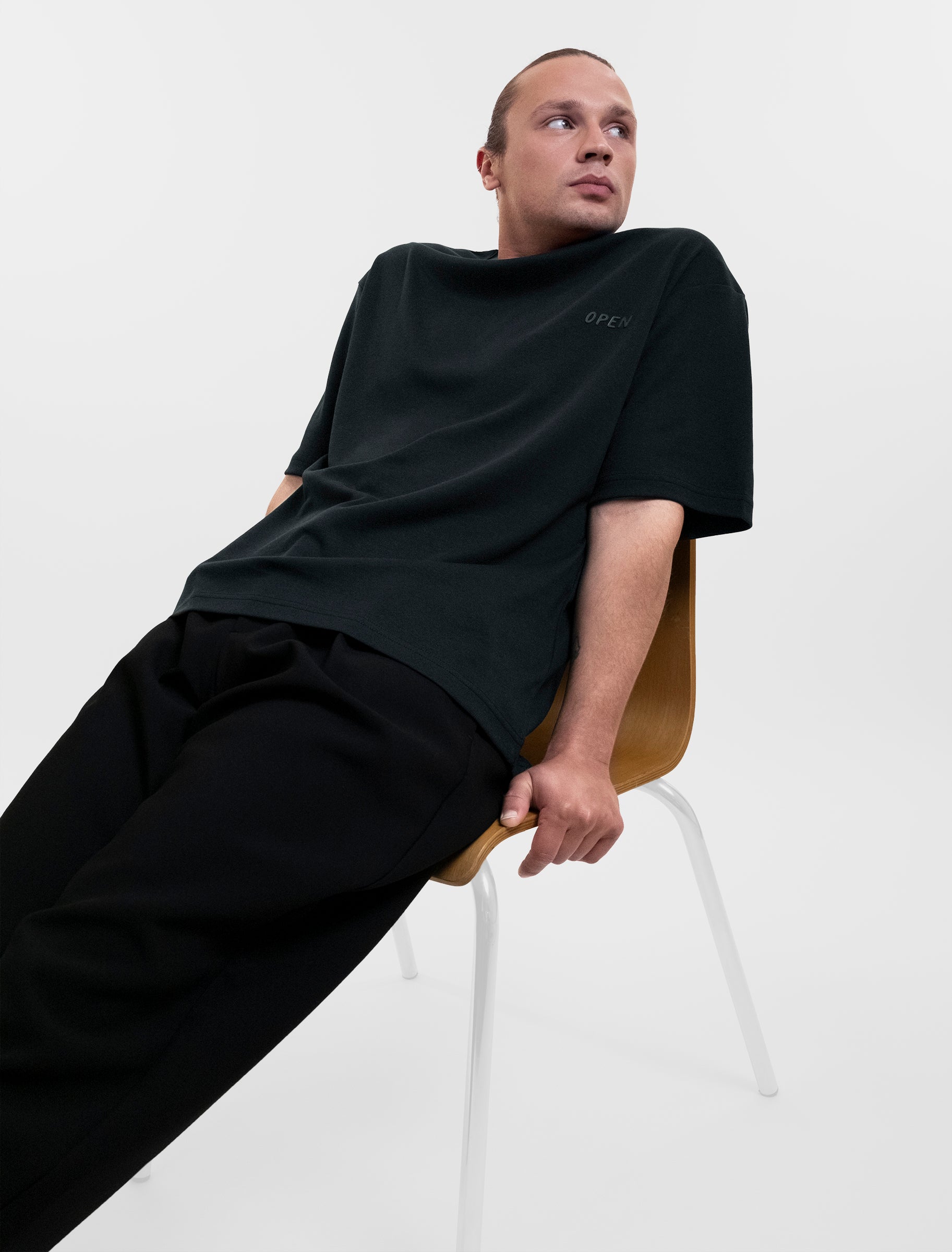 Open Row Men's Open Heart Tee in black, reclining pose.
