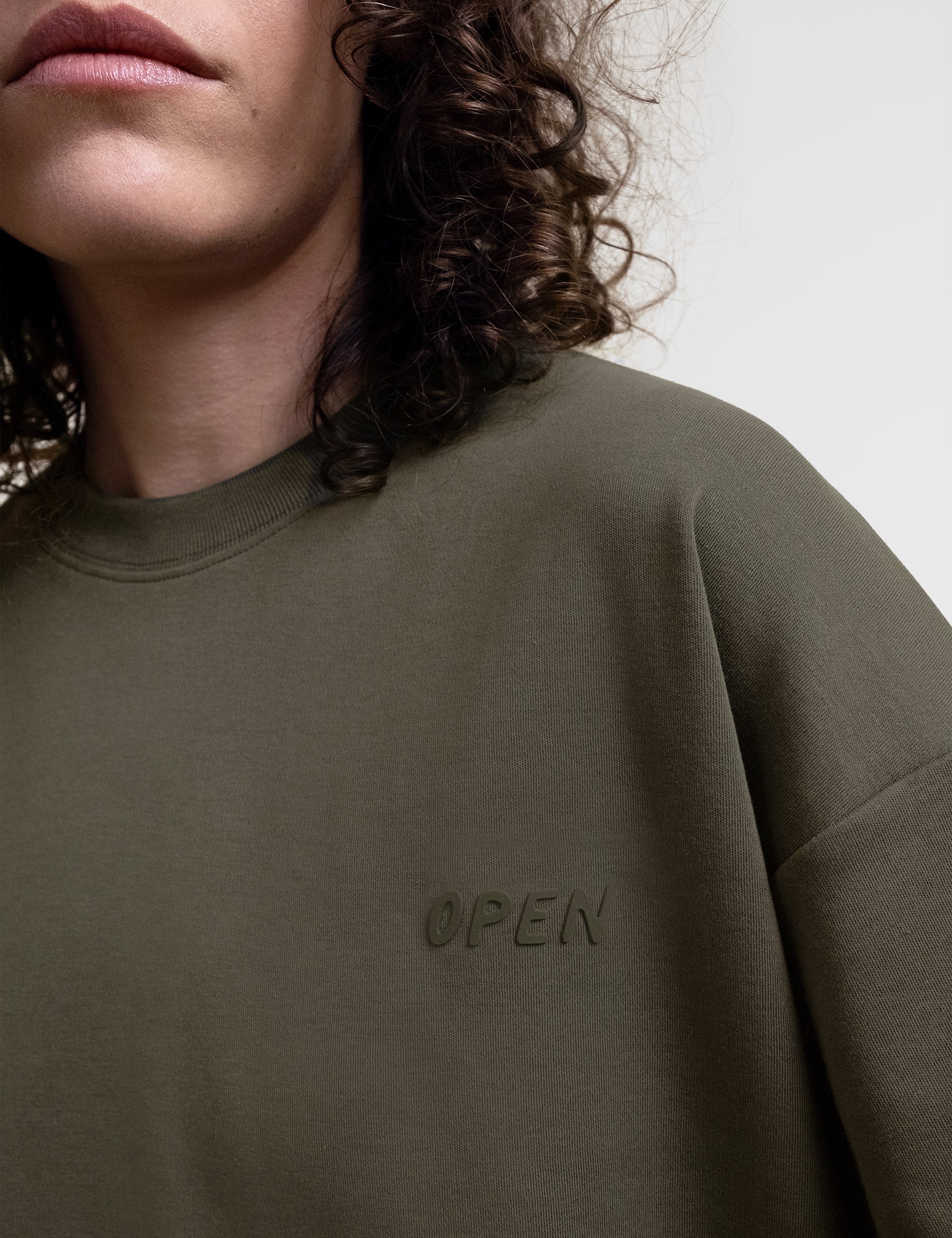 Open Row Women's Open Heart Tee in khaki green, closeup view, embossed logo detail.