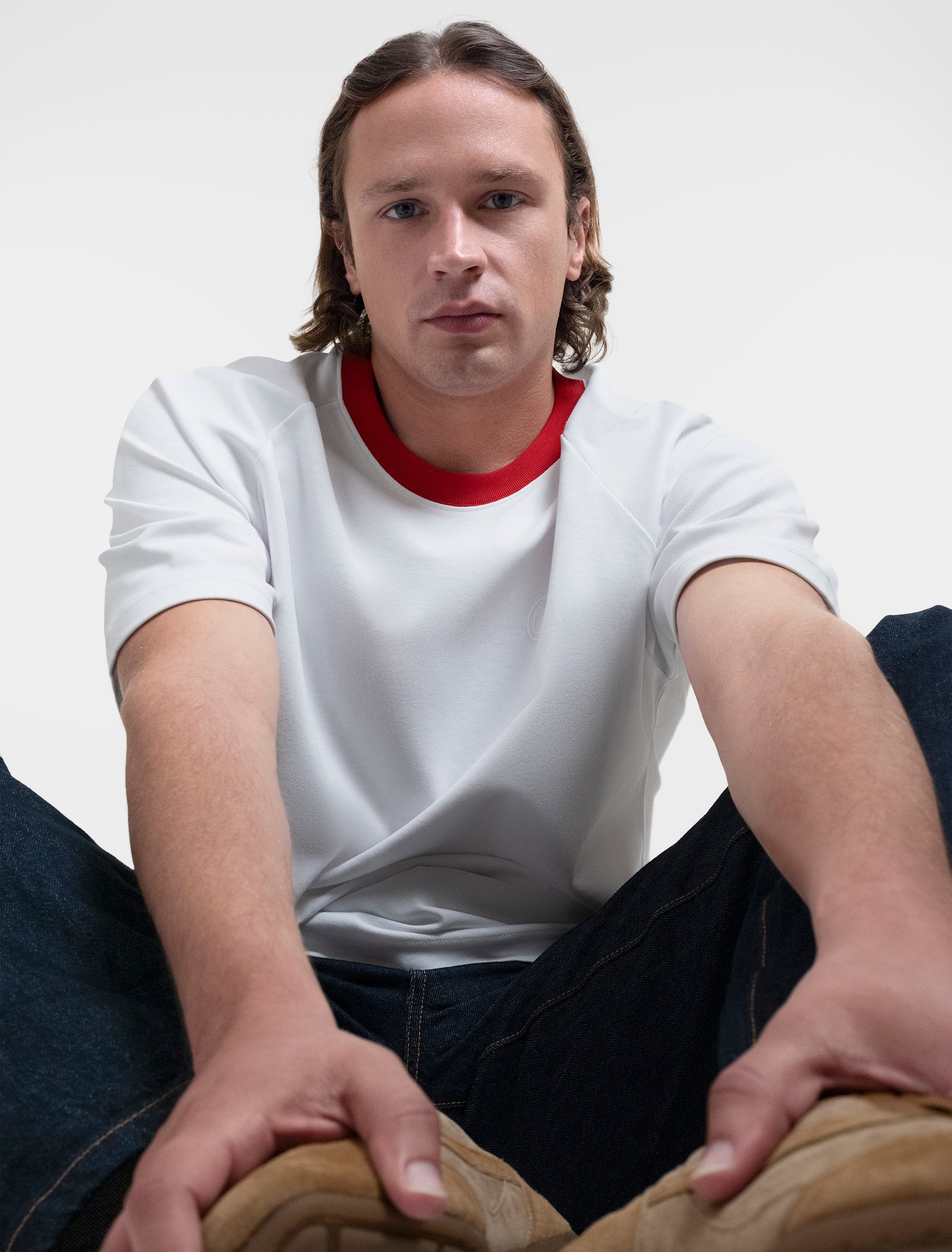 Open Row Men's Runaway Tee in white with red collar, editorial view paired with jeans.