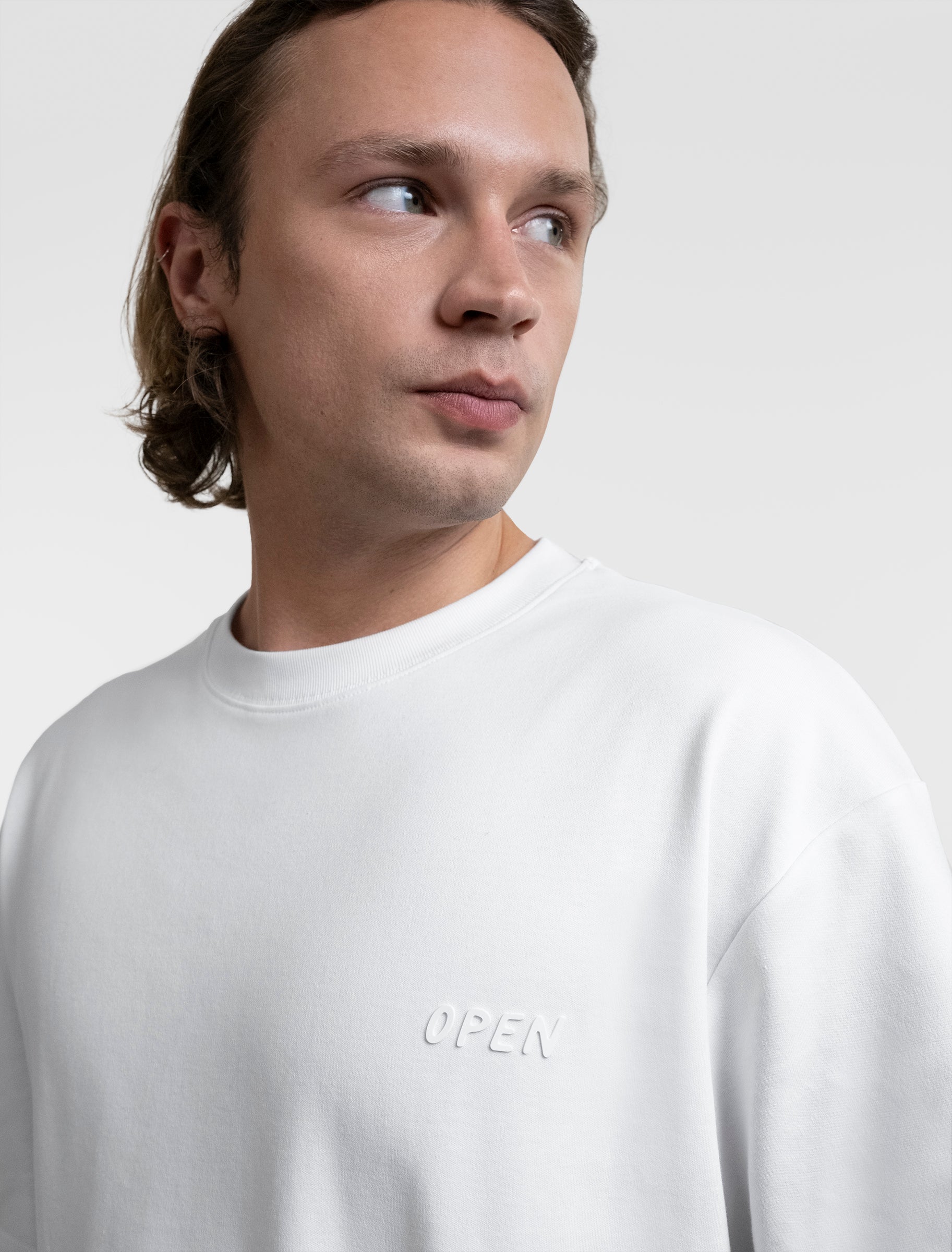 Open Row Men's Open Heart Tee in white, closeup view, embossed logo detail.