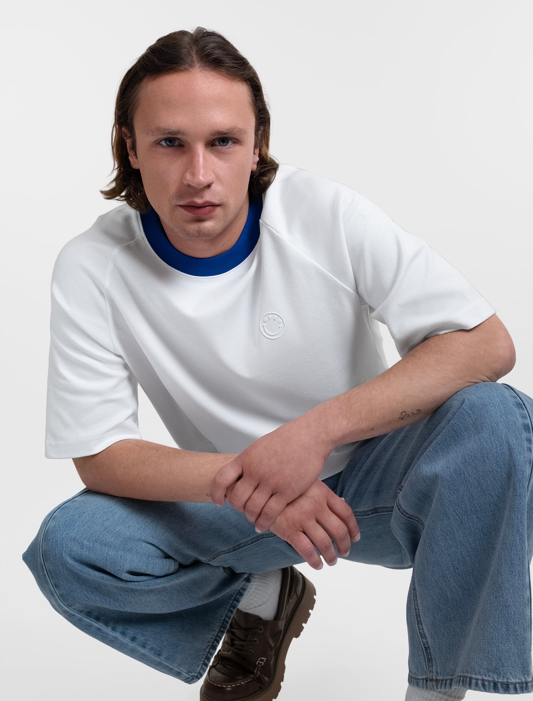 Open Row Men's Runaway Tee in white with blue collar, editorial view.