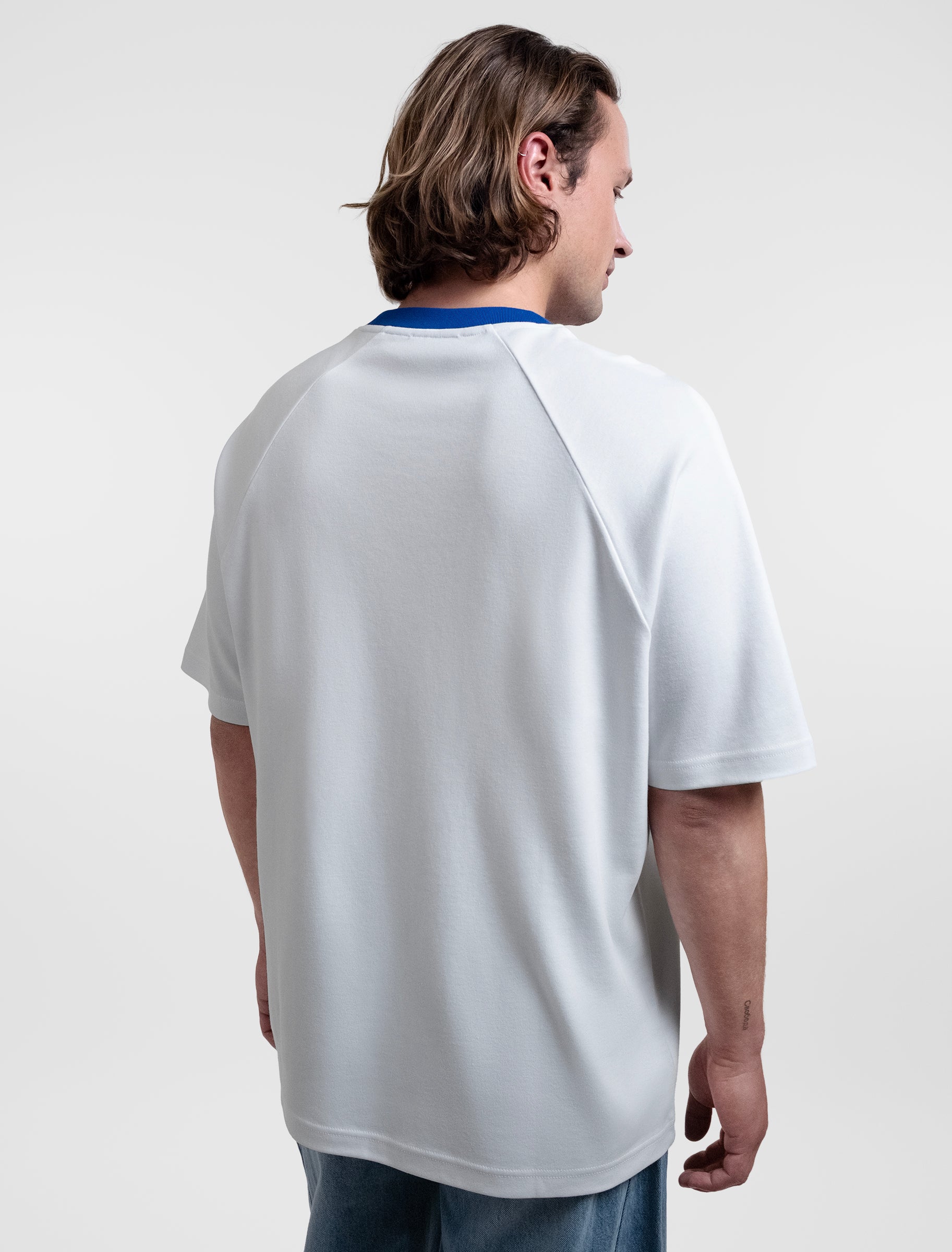 Open Row Men's Runaway Tee in white with blue collar, three-quarter back view.
