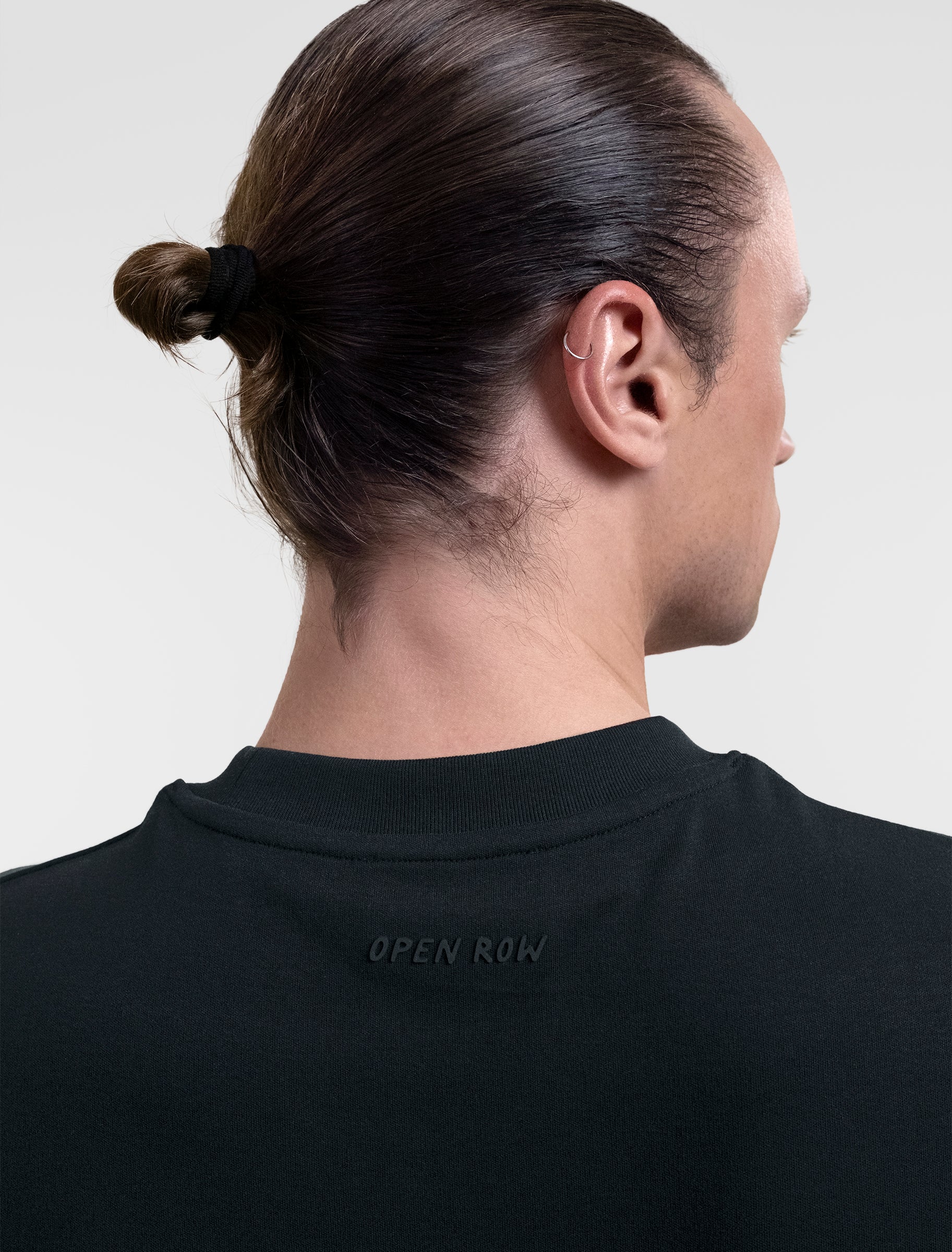 Open Row Men's Tank Tee in black, closeup view, embossed logo detail.