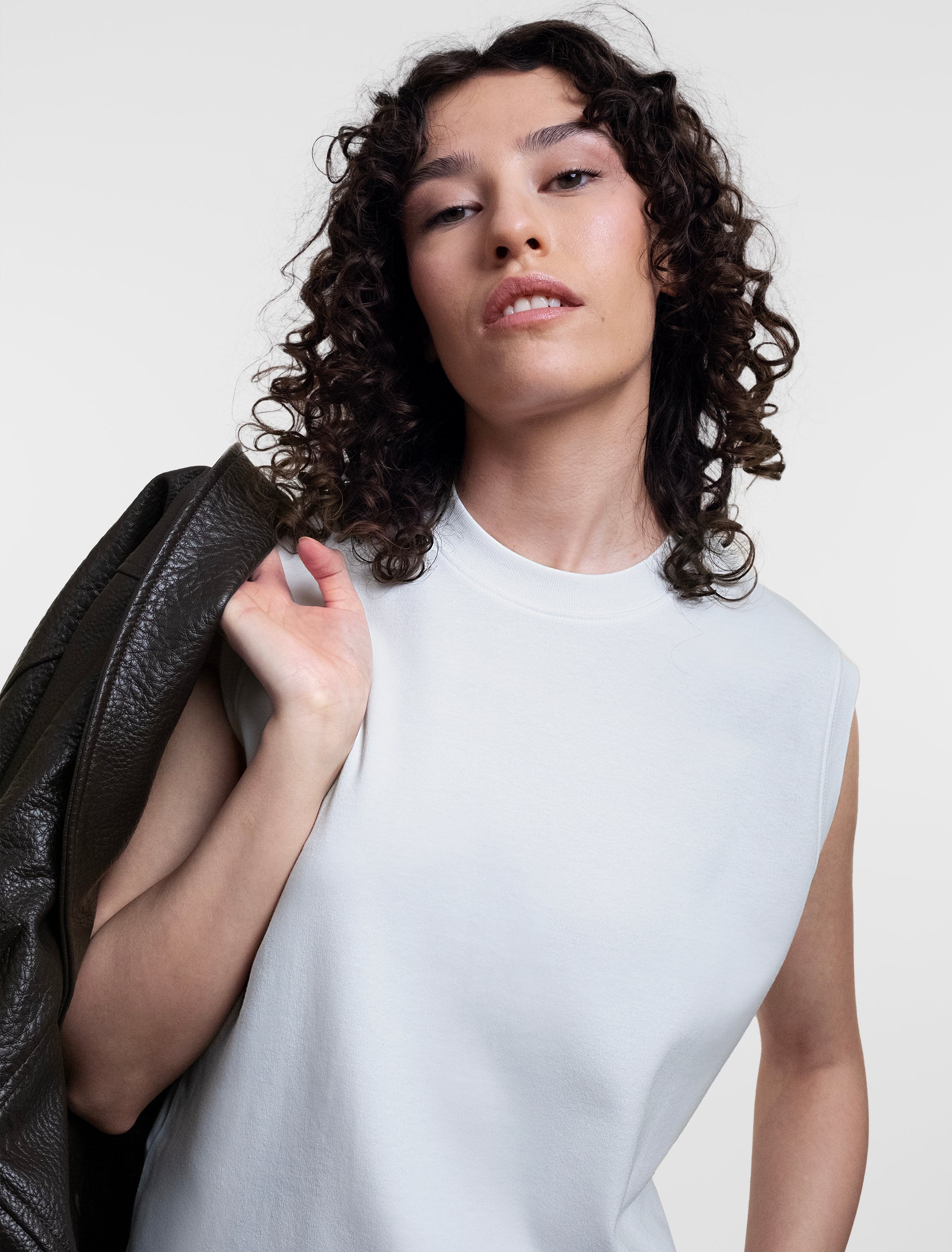 Open Row Women's Tank Tee in white, front editorial view paired with a leather jacket.